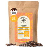 A 1LB bag of Kochere Coffee Colombian Medellin Single Origin Medium Roast by Kochere Coffee Company is shown, featuring dried orange and berry notes, with whole beans scattered in front.