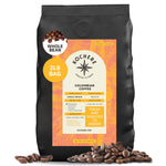 A 2-pound bag of Kochere Coffee Colombian Medellin Single Origin Medium Roast—dried orange and berry notes—by Kochere Coffee Company, with an orange-yellow label showing origin and roast details; coffee beans scattered nearby.