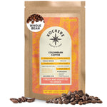 A 12 oz bag of Kochere Coffee Company’s Colombian Medellin Single Origin Medium Roast stands upright, coffee beans scattered in front. The label highlights dried orange and berry notes, plus single origin and medium roast features.