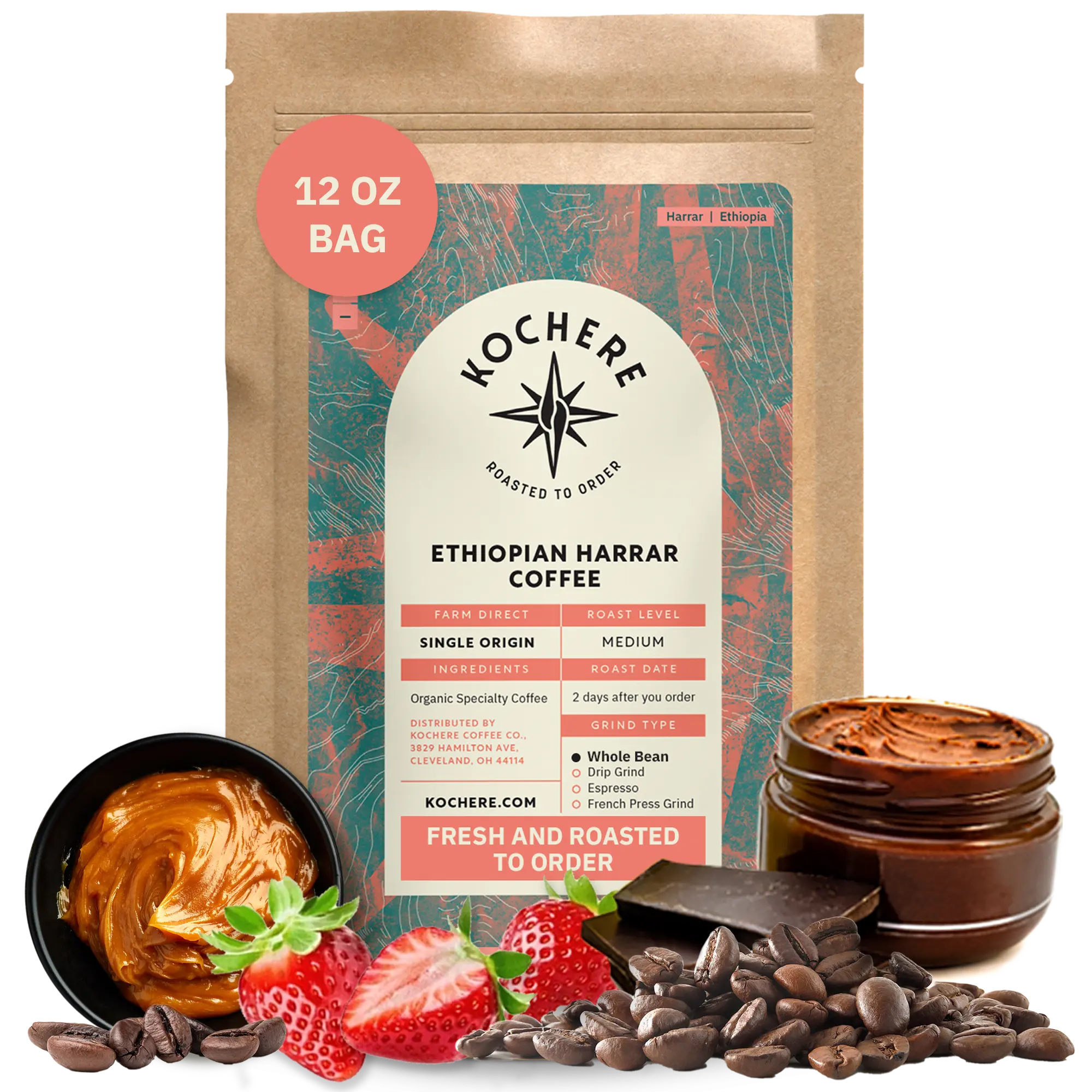 A 12 oz bag of Kochere Coffee Ethiopian Harrar Natural Medium Roast by Kochere Coffee Company stands upright, surrounded by coffee beans, strawberries, chocolate pieces, and a jar of chocolate spread.
