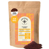 A 1-pound bag of Kochere Coffee Company Colombian Medellin Single Origin Medium Roast, with dried orange and berry notes, fine grind, is shown with ground coffee spilled beside the package. [1lb][fine grind]