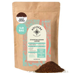 A 1lb resealable kraft bag of Kochere Coffee Company's Ethiopian Sidamo Natural Medium-Light Roast, featuring milk chocolate and fruity notes, sits upright with drip-grind coffee grounds spilled in front.