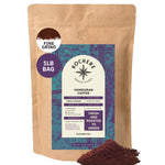 A 1lb bag of Kochere Coffee Company’s Honduran Marcala Organic Medium Roast (Caramel, Spice, Brown Sugar notes) in fine grind, with a purple and teal label and a small pile of ground coffee in front.
