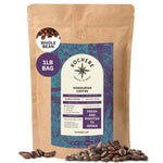A 1 lb bag of Kochere Coffee Company’s Honduran Marcala Organic Medium Roast—featuring caramel, spice, and brown sugar notes—is surrounded by coffee beans, ideal for fair trade coffee lovers.