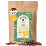 A 1-pound bag of Kochere Coffee Company Kenyan Nyeri Embu AB Medium-Light Roast, featuring lemon and blackberry notes, with a teal and yellow label surrounded by scattered coffee beans.