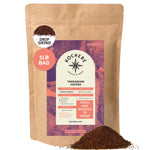 Kochere Coffee Company’s Tanzanian Mbeya AB, 1 lb bag, medium-light roast, drip grind—labeled "Fresh and roasted to order"—features vibrant pear, floral, and jasmine notes; some coffee grounds spilled at the base.