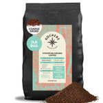 A 2lb bag of Kochere Coffee Company’s Ethiopian Sidamo Natural Medium-Light Roast, with milk chocolate and fruity notes, labeled coarse grind, shown with ground coffee artfully spilled in front.