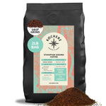A 2lb bag of Kochere Coffee Ethiopian Sidamo Natural Medium-Light Roast by Kochere Coffee Company, featuring milk chocolate and fruity notes, with drip grind beside the bag. Packaging emphasizes freshness and single origin.