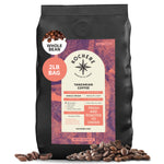 A 2lb bag of Kochere Coffee Tanzanian Mbeya AB Medium-Light Roast by Kochere Coffee Company, whole bean, with origin and roast details on the label. Features pear, floral, and jasmine notes; beans are scattered around the bag.