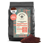 A 5lb bag of Kochere Coffee Ethiopian Harrar Natural Medium Roast by Kochere Coffee Company—fresh, single origin, organic beans with fruity blueberry and dark chocolate notes, available in fine grind. Some ground coffee sits beside the bag.
