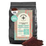A 5lb bag of Kochere Coffee Company’s Ethiopian Sidamo Natural Medium-Light Roast coffee, with milk chocolate and fruity notes, fine grind, is shown with coffee grounds displayed in front of the package.