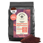 A 5lb bag of Kochere Coffee Company’s Tanzanian Mbeya AB, a single origin medium-light roast with pear, floral, and jasmine notes. Freshly roasted to order, ground fine, with coffee grounds shown in front of the bag.