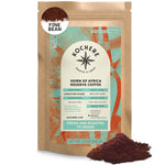 A brown bag labeled "Kochere Coffee Horn of Africa Reserve Signature Espresso Blend - Medium-Dark Roast" from Kochere Coffee Company sits upright with spilled grounds, highlighting its specialty blend and freshness.