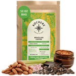 Bag of Kochere Single Origin Brazilian medium roast coffee, displayed with raw almonds, fresh lemongrass, and dark chocolate to represent its balanced, aromatic flavor profile. [12 oz][Whole Bean]