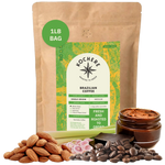Bag of Kochere Single Origin Brazilian medium roast coffee, displayed with raw almonds, fresh lemongrass, and dark chocolate to represent its balanced, aromatic flavor profile. [1LB][Whole Bean]