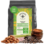 Bag of Kochere Single Origin Brazilian medium roast coffee, displayed with raw almonds, fresh lemongrass, and dark chocolate to represent its balanced, aromatic flavor profile. [5LB][Whole Bean]