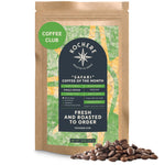 A 12oz bag of Kochere Coffee Company's Kochere Safari "Coffee of the Month" Club—fresh roasted, single-origin medium roast subscription—features scattered coffee beans in front of the package.