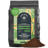 A 5 lb bag of Kochere Coffee Company’s Safari "Coffee of the Month" Club—fresh roasted, single origin medium roast, with ground coffee in front. The label features its roast level, origin, freshness, and monthly subscription details.