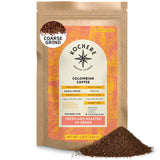 A 12oz bag of Kochere Coffee Company's Colombian Medellin Single Origin Medium Roast, featuring dried orange and berry notes, coarse grind with some grounds spilled in front; packaging shows origin, roast level, and grind type.[12 oz][coarse grind]