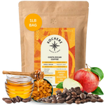 A 1lb bag of Kochere Coffee Costa Rican Alajuela Medium Roast by Kochere Coffee Company is showcased with coffee beans, red apple, honey, and raisins in front to highlight its sweet apple and raisin notes.[1LB][Whole Bean]