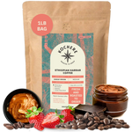 A 1lb bag of Kochere Coffee Company’s Ethiopian Harrar Natural Medium Roast is shown with coffee beans, strawberries, chocolate, nut butter swirls, and a cup of brewed coffee highlighting its fruity, berry, and dark chocolate notes.[1LB][Whole Bean]