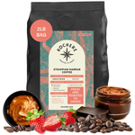 A 2lb bag of Kochere Coffee Company's Ethiopian Harrar Natural Medium Roast features notes of fruit, berries, and dark chocolate. The label highlights its single origin and freshly roasted quality, displayed with strawberries, chocolate, beans, and caramel.[2LB][Whole Bean]