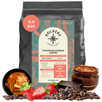 A 5-pound bag of Kochere Coffee Company’s Ethiopian Harrar Natural Medium Roast, featuring fruity, berry, and dark chocolate notes, is pictured among chocolate, strawberries, coffee beans, and nut butter with product details on the label.[5LB][Whole Bean]