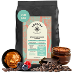 Bag of Kochere Single Origin Ethiopian Sidamo medium-light roast coffee, displayed with rich caramel, fresh berries, and dark chocolate to represent its decadent flavor profile. [2LB][Whole Bean]