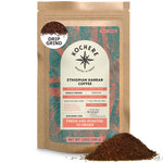 A 12oz bag of Kochere Coffee Ethiopian Harrar Natural Medium Roast by Kochere Coffee Company—single origin, drip ground, and featuring fruity, berry, and dark chocolate notes—with organic coffee beans beside the bag.[12 oz][drip grind]