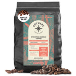 A black bag of Kochere Coffee Ethiopian Harrar Natural Medium Roast whole beans, with a detailed label, sits amid scattered organic beans—highlighting fruity blueberry and dark chocolate notes. Brand: Kochere Coffee Company.