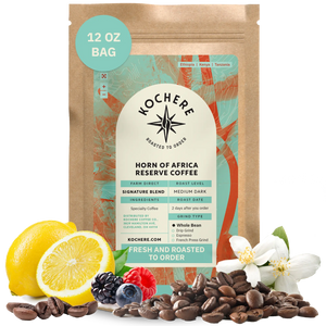 Kochere Horn of Africa Reserve medium-dark roast coffee, displayed with fresh lemons, berries, and white blossoms to represent its flavor profile. [12 oz][whole bean]