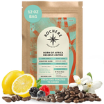 Kochere Horn of Africa Reserve medium-dark roast coffee, displayed with fresh lemons, berries, and white blossoms to represent its flavor profile. [12 oz][whole bean]