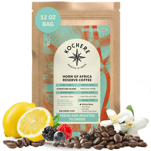 Kochere Horn of Africa Reserve medium-dark roast coffee, displayed with fresh lemons, berries, and white blossoms to represent its flavor profile. [12 oz][whole bean]