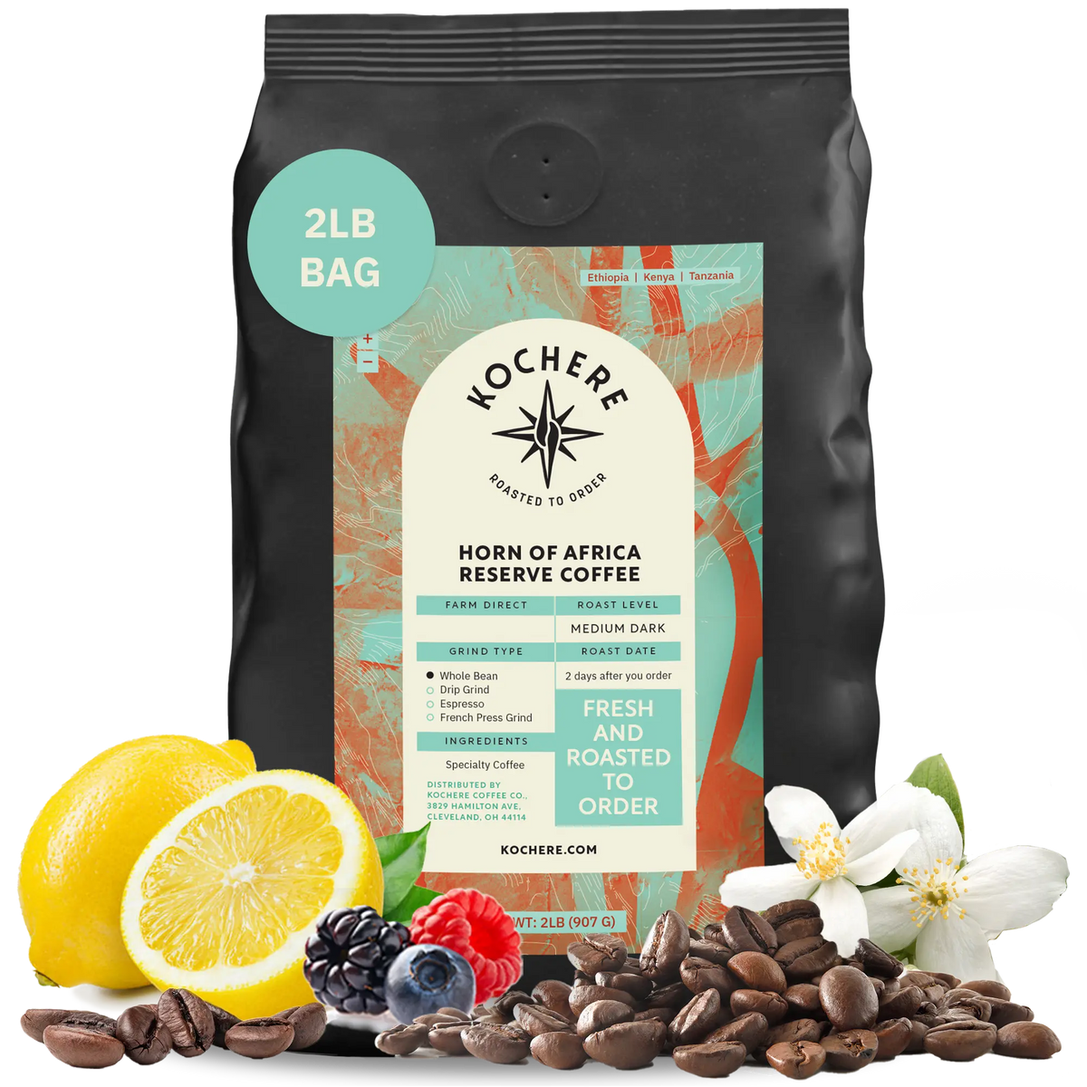 Kochere Horn of Africa Reserve medium-dark roast coffee, displayed with fresh lemons, berries, and white blossoms to represent its flavor profile. [2LB][whole bean]