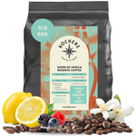 Kochere Horn of Africa Reserve medium-dark roast coffee, displayed with fresh lemons, berries, and white blossoms to represent its flavor profile. [5LB][whole bean]