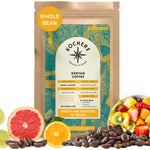 A 12oz bag of Kochere Coffee Kenyan Nyeri Embu AB Medium-Light Roast by Kochere Coffee Company, featuring lemon and blackberry notes, is displayed surrounded by fresh fruits and coffee beans.