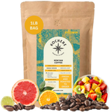 A 1 lb bag of Kochere Coffee Company’s Kenyan Nyeri Embu AB Medium-Light Roast is displayed with coffee beans, fruit salad, grapefruit, orange, and lime slices. The label notes its fruity, balanced, bright cup profile and fresh-to-order roasting.