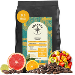 A 2lb bag of Kochere Coffee Kenyan Nyeri Embu AB by Kochere Coffee Company sits among fresh fruit, citrus slices, and coffee beans—highlighting the fruity, balanced, and bright notes of this medium-light roast.[2LB][Whole Bean]