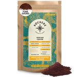 A 12oz bag of Kochere Coffee Kenyan Nyeri Embu AB, a medium-light roast with lemon and blackberry notes by Kochere Coffee Company, is shown next to a pile of ground coffee.