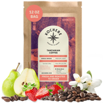 Bag of Kochere Single Origin Tanzanian medium-light roast coffee, displayed with fresh pears, sweet strawberries, and white blossoms to represent its crisp and aromatic flavor profile. [12 oz][Whole Bean]