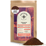 A 12oz bag of Kochere Coffee Company Tanzanian Mbeya AB Medium-Light Roast, single origin, drip grind, with pear, floral, and jasmine notes, shown with a bit of ground coffee spilled in front.