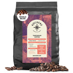 A 5 lb bag of Kochere Coffee Company’s Tanzanian Mbeya AB Medium-Light Roast whole beans offers pear, floral, and jasmine notes, with beans displayed in front of the packaging.