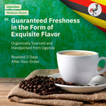An advertisement for Ugandan medium roast coffee. The top half of the image has a green, textured background featuring a topographic map design and the flag of Uganda in the top right corner. The bottom half shows a white coffee cup and saucer sitting on a burlap sack next to a pile of roasted coffee beans. [all]